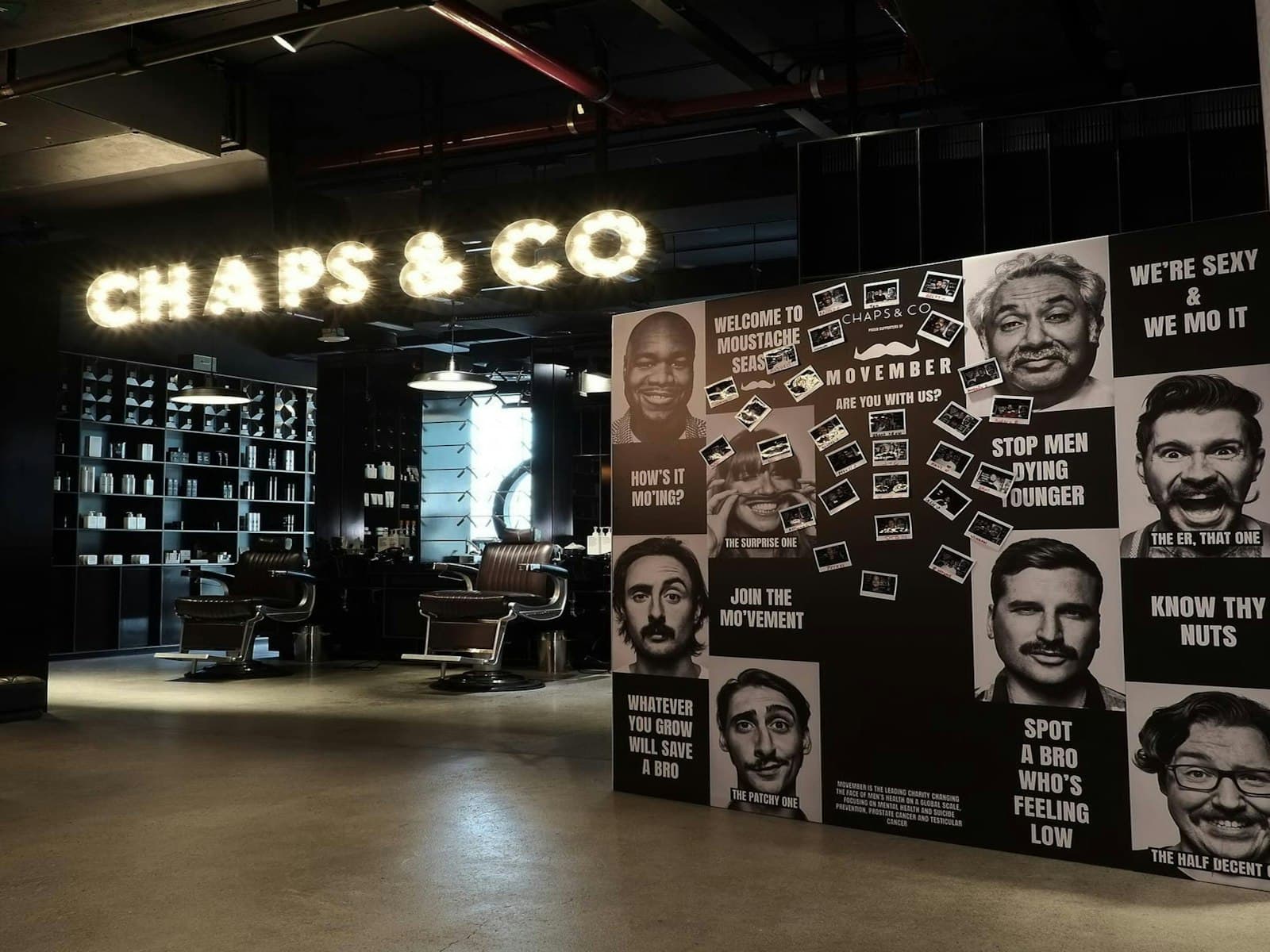 Barbearia com letreiro luminoso e cadeiras em pele