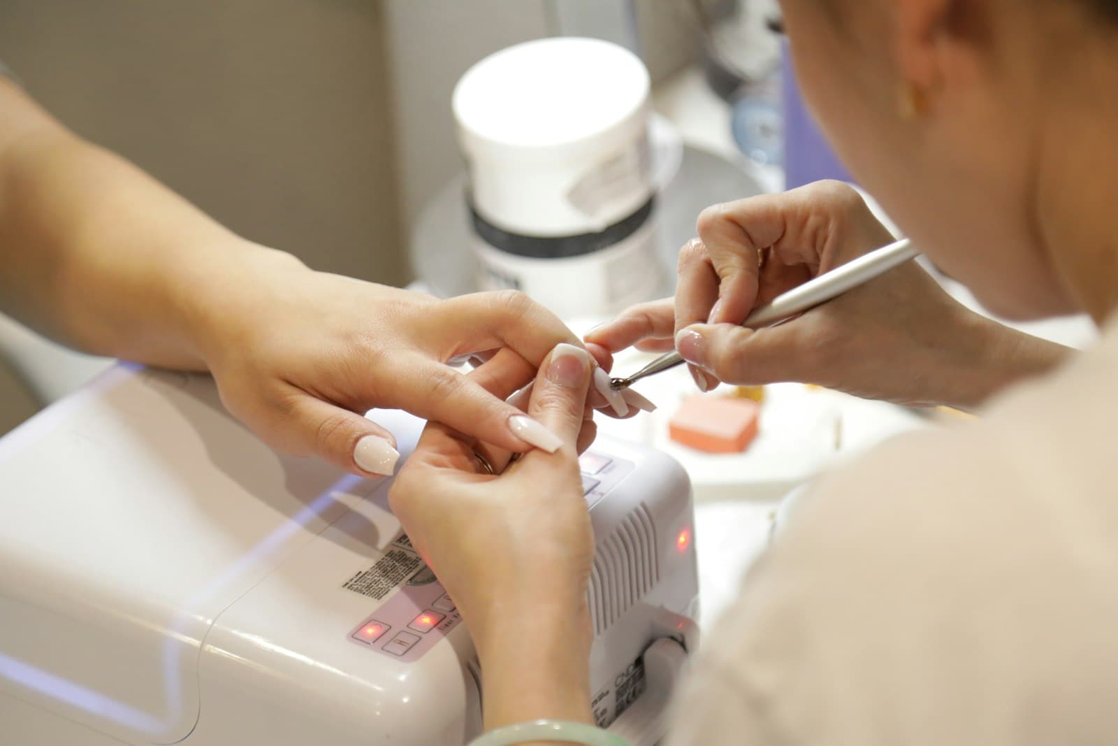 Manicure a trabalhar as unhas de uma cliente