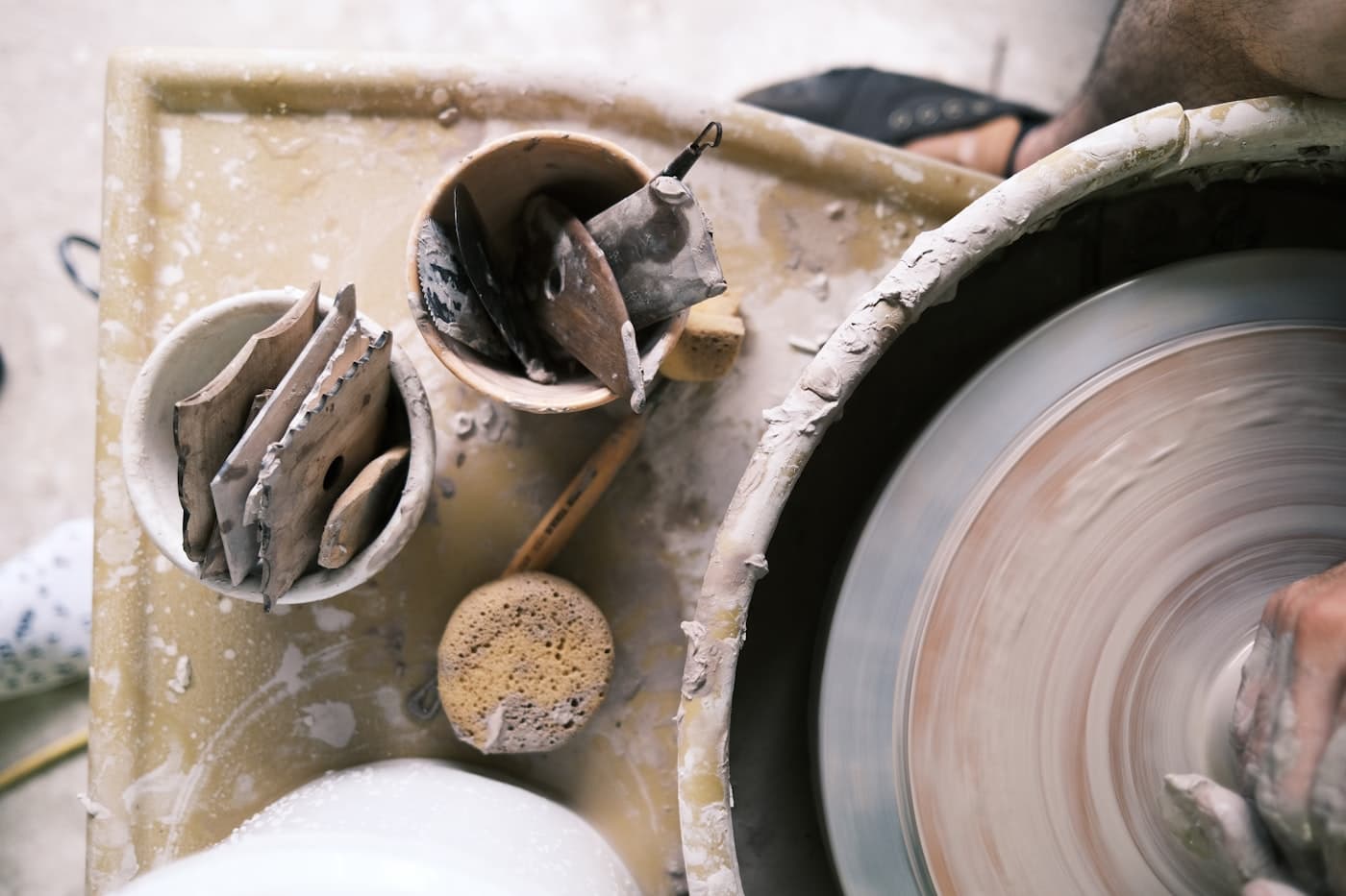Roda de oleiro e ferramentas de cerâmica num atelier