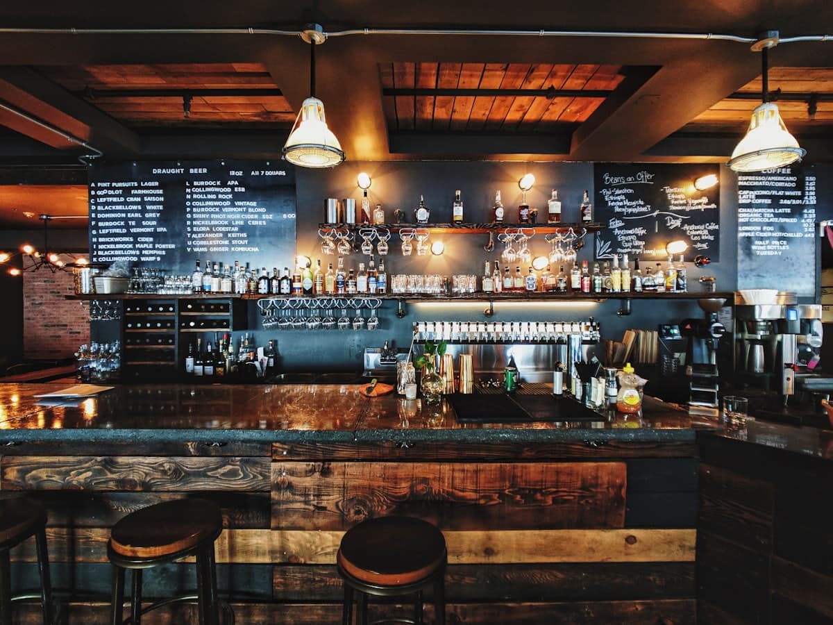 Balcão de bar com torneiras de cerveja e bancos altos